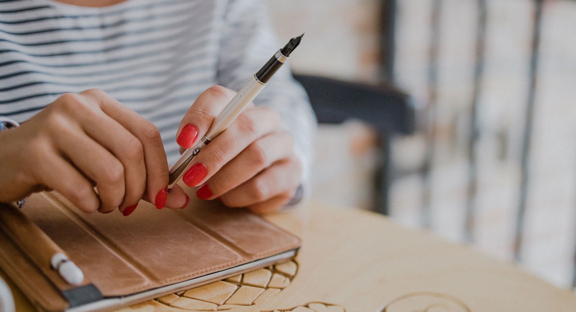 Frauenhand mit Stift über pad auf rundem Holztisch